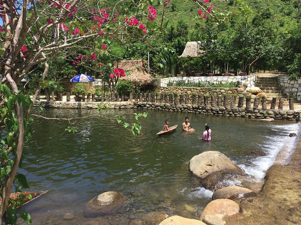 Đắm mình trong bể bơi tại khu du lịch lái Thiêu Đà Nẵng bao quanh là cây cối xanh mát